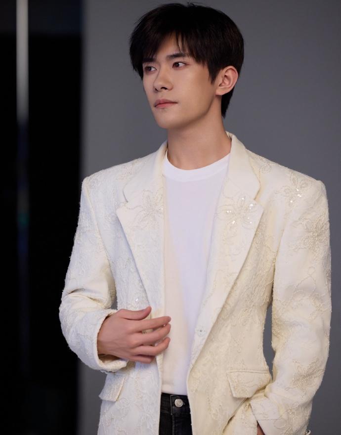 易烊千玺的刺绣西装在细节处彰显品味，针脚细密纹样独特，他观看的充电处方聚焦康复细