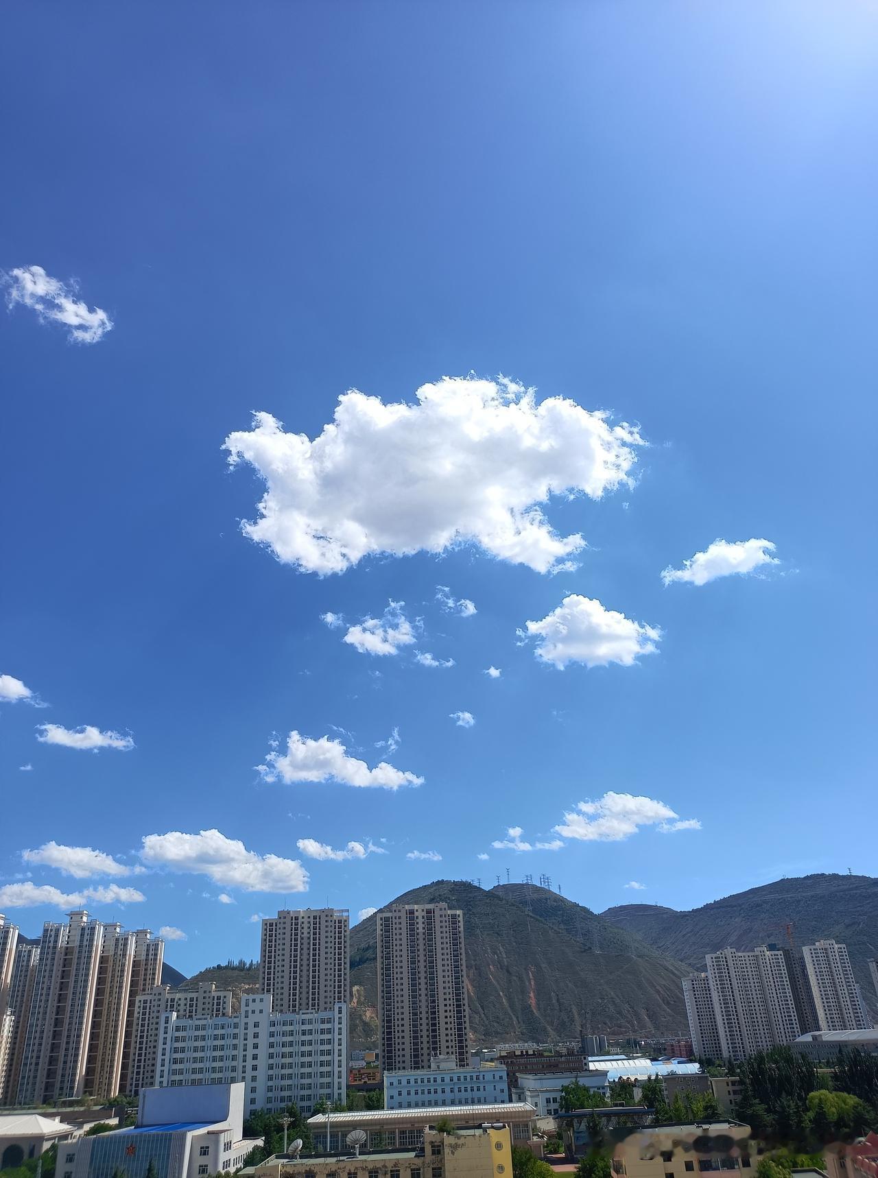 正午的天空，颜色是一种少有的蓝，云的颜色，白的也让人悠然，虽然气温不低，这天空，