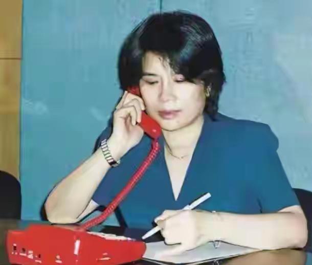 一位女士正在打电话，同时写笔记。大家猜猜她是谁，评论区留言。