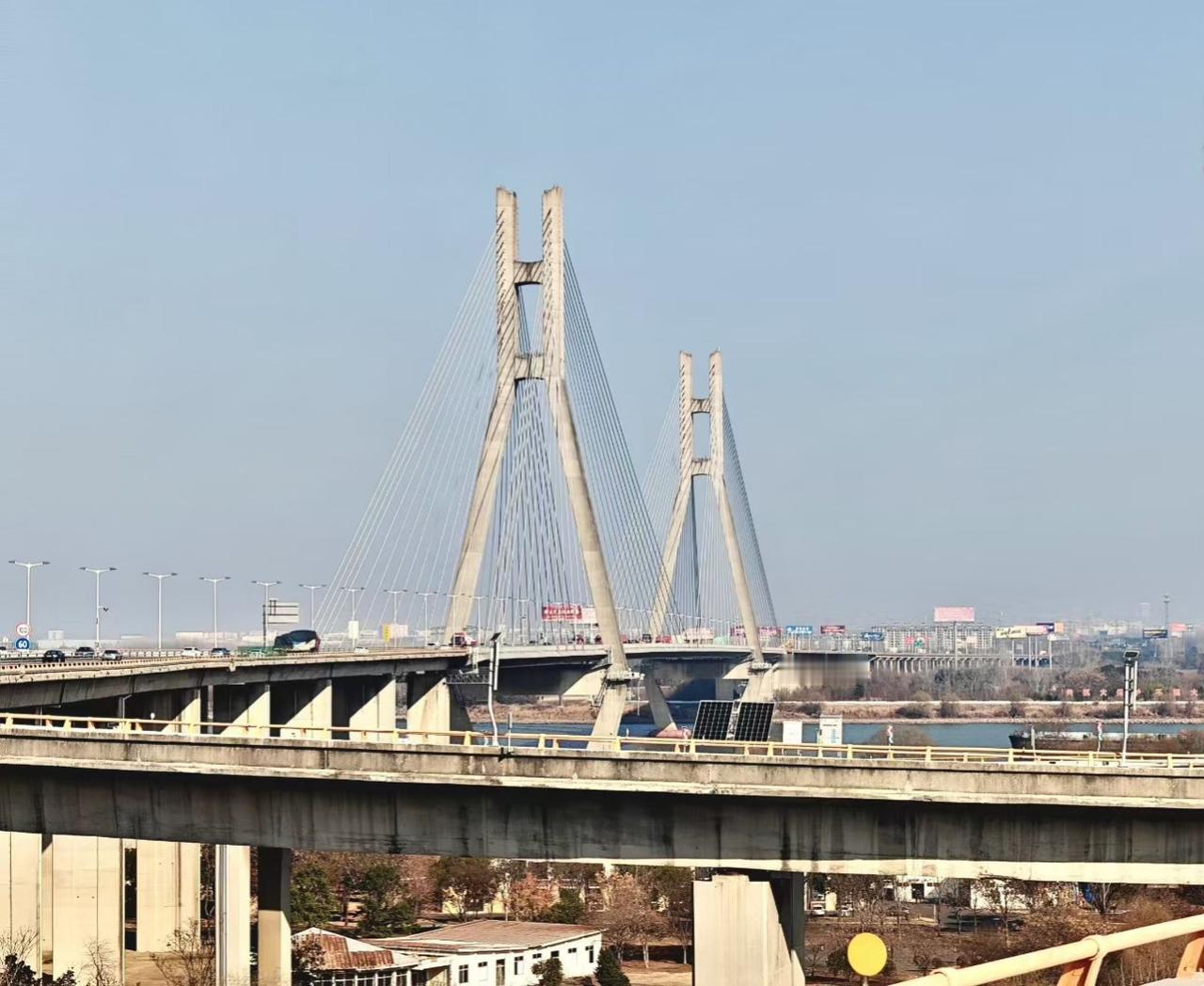 🌉 钢索把天空拉成蛛网，车流在桥身织出光的溪流，城市的脉搏在水泥与金属间震颤。