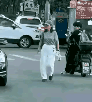 马路无故踹车太离谱！
 大马路上一名女子毫无章法地在路中间闲逛，路上车来车往特别