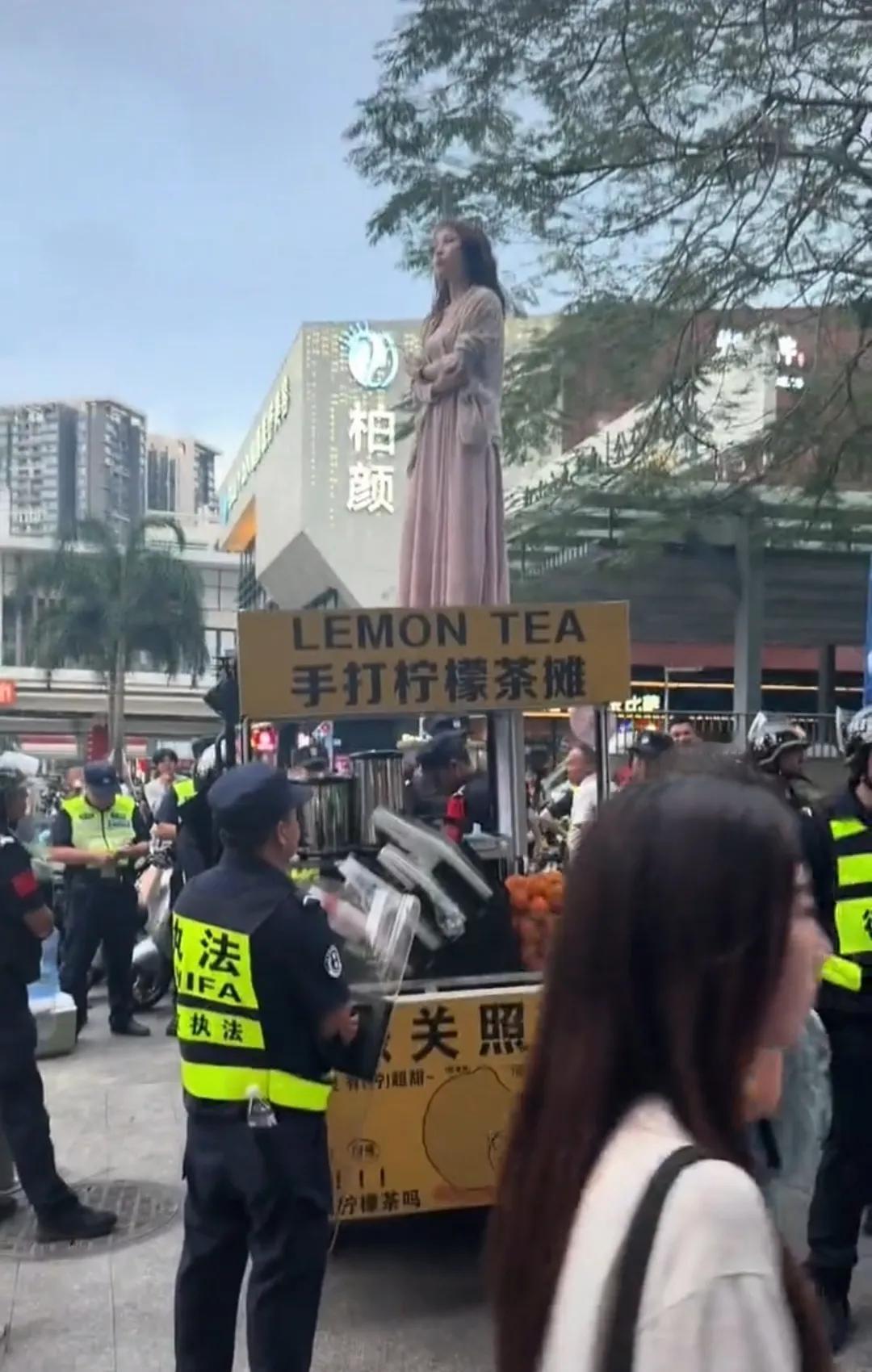 深圳一女子为了自己的摊子不被收走，直接爬到了摊车顶上，女子一下子就成为了深圳最靓