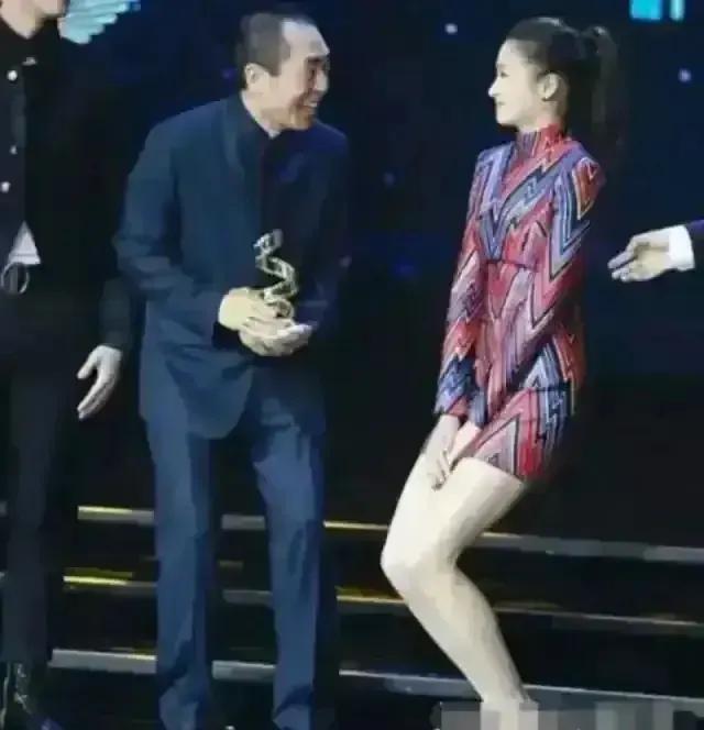 一次颁奖晚会上，张艺谋走向关晓彤时，只见她双腿紧闭，双手捂裙，双膝往下蹲。张艺谋