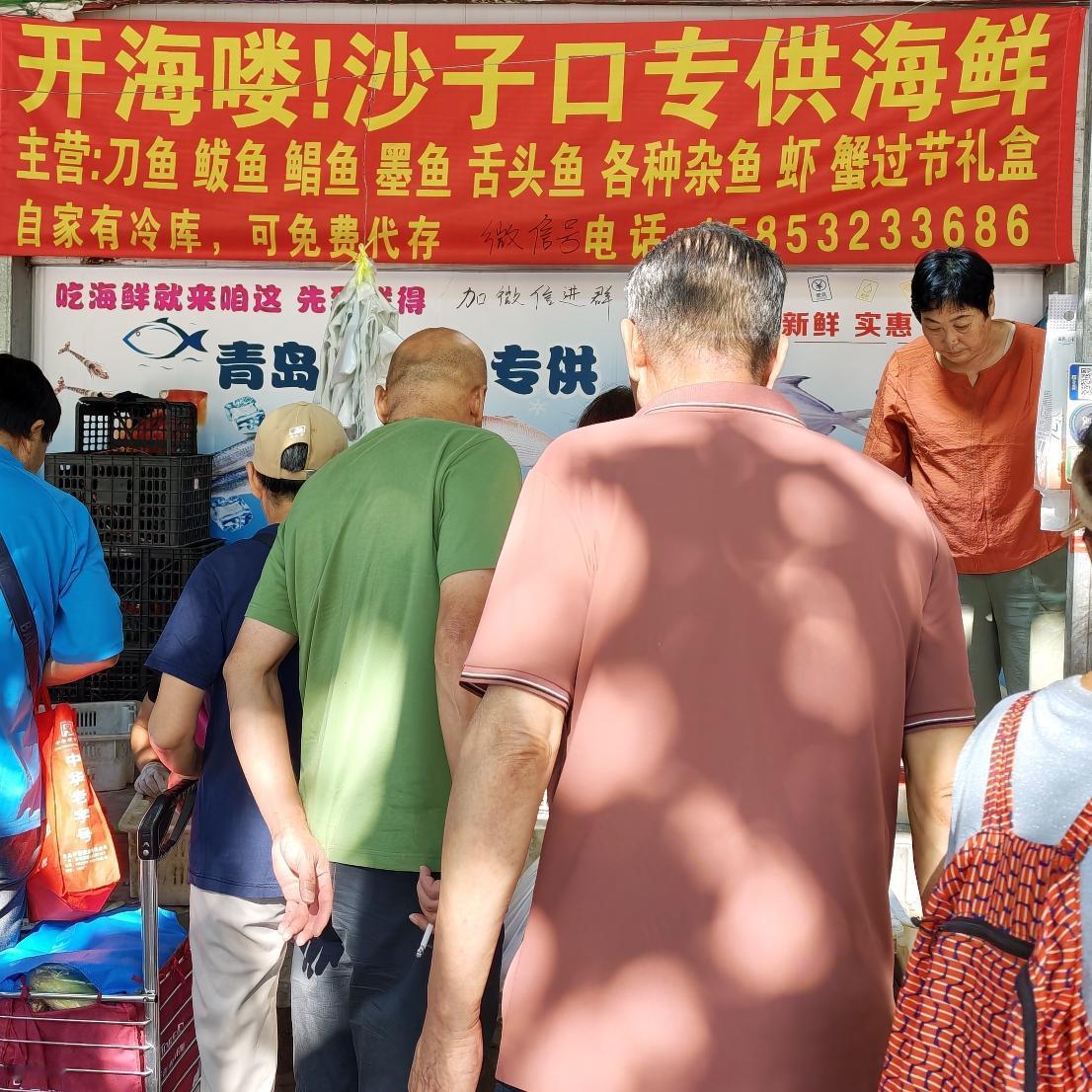 这海鲜店也挺火爆的，围拢了好多人前来购买。
这里的海鲜说是沙子口专供的，都是当天