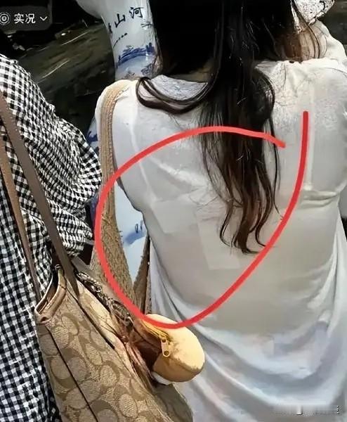路人随手拍下的一幕，在网上火速刷屏！一位身着白短袖的女生，后背位置藏了东西格外显