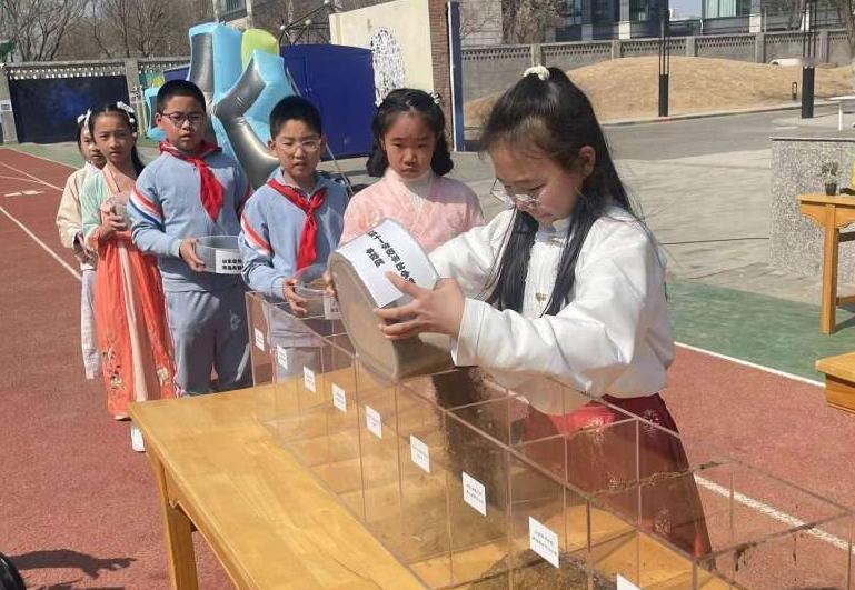 北京十一学校丰台小学热闹非凡，吉祥物石榴娃在孩子们中间欢快地穿梭，与大家共唱二十