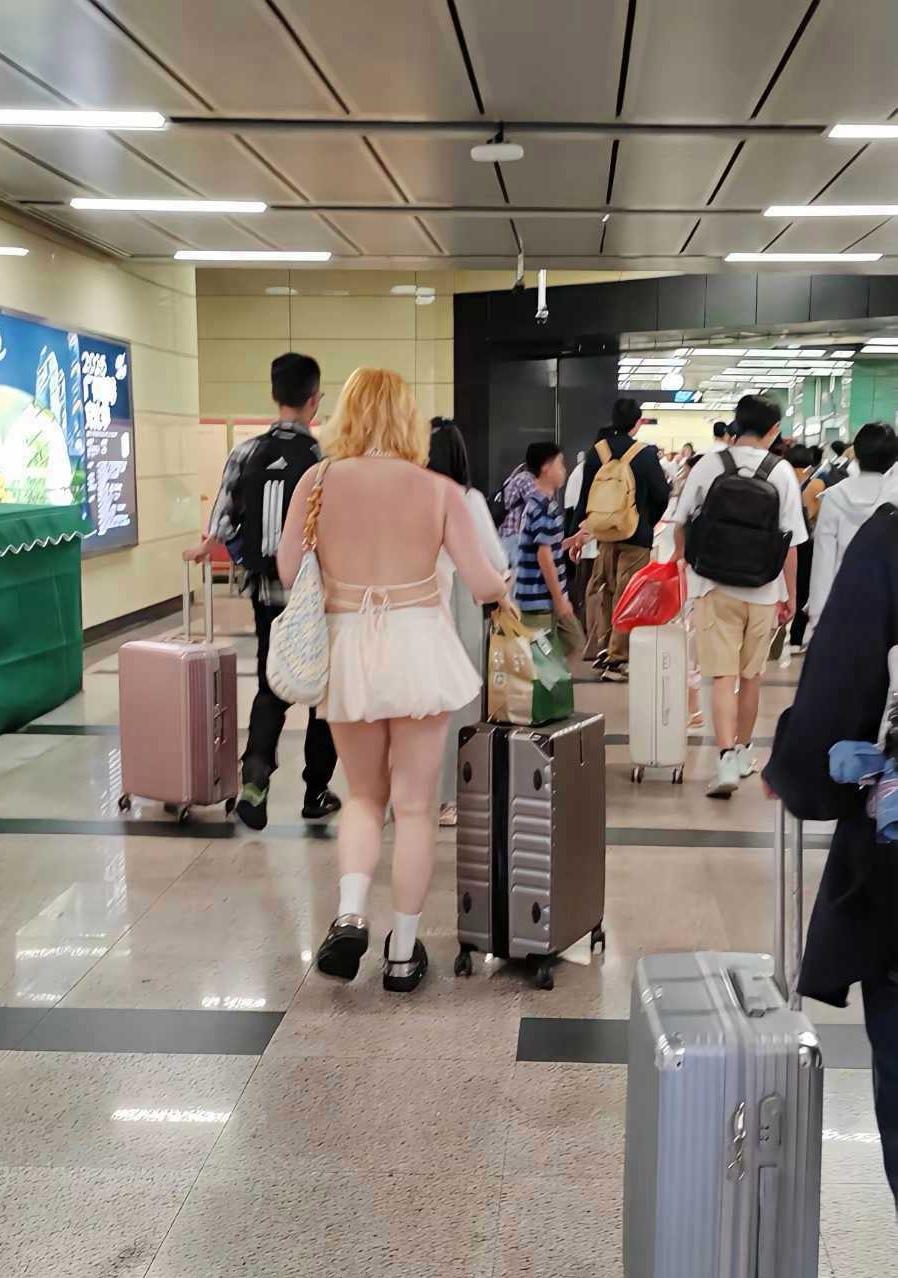 辣眼睛！女人穿露背装太吸睛

图片1，某地高铁站出口，见一位留着黄头发的胖女人，
