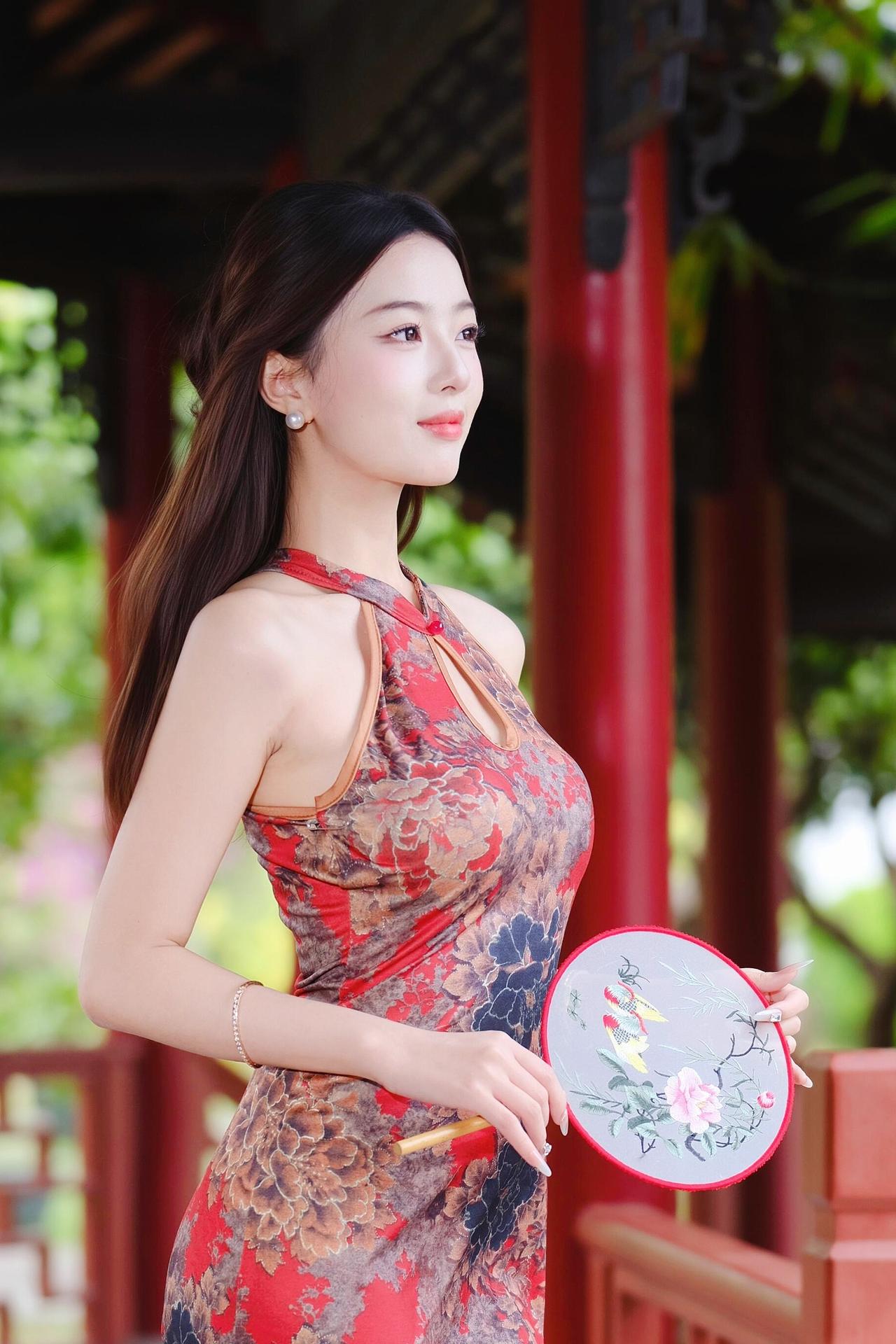 《亭畔旗袍》
 原创诗词 原创看图片配诗 
丹衣缠颈缀花浓，团扇轻摇亭下风。
石