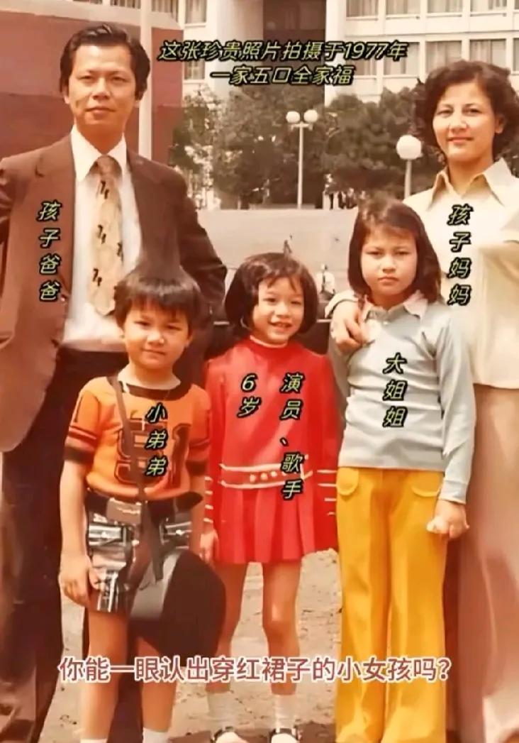 这是1977年的一张全家福，你能一眼认出那个穿着红裙子的小女孩呢？

那一年，她