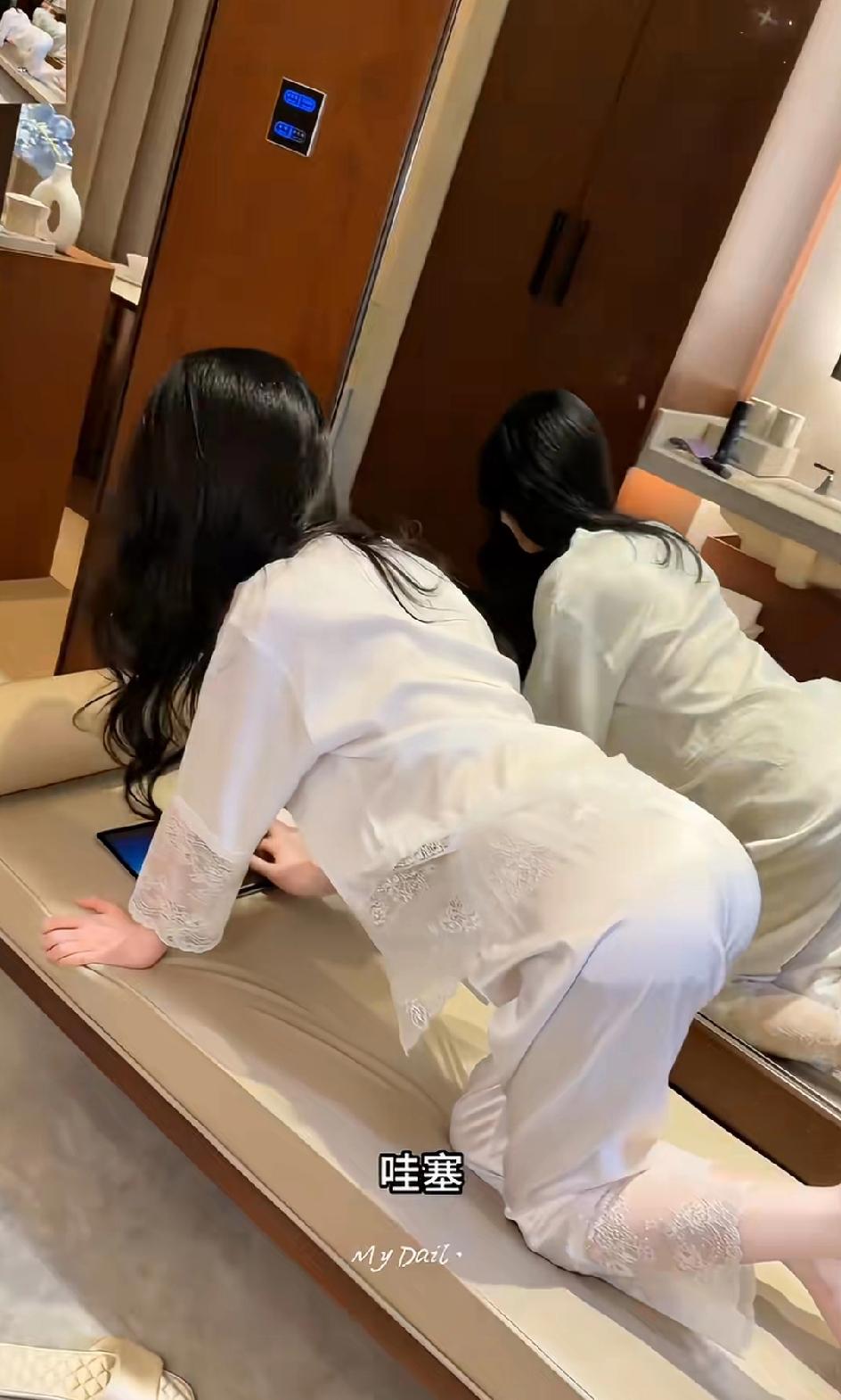 女子在好朋友面前展示自己的新款睡衣她自信的说道：有了这款睡衣自己睡觉都是香的，有