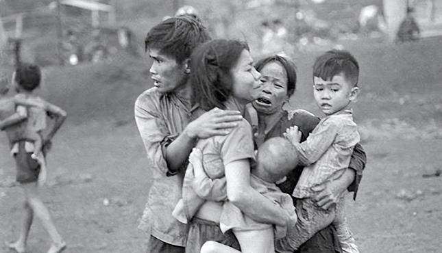 1969年的西贡街头，阳光把美国大兵的枪管晒得发烫。

骨瘦如柴的女人弓着背，脸