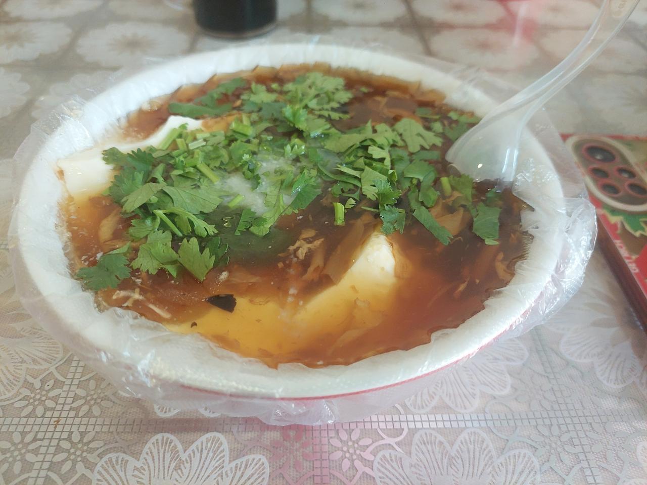 早餐，于我自己来说，本来觉得一碗豆腐脑足够。

还是又要了一个角瓜鸡蛋包子。
