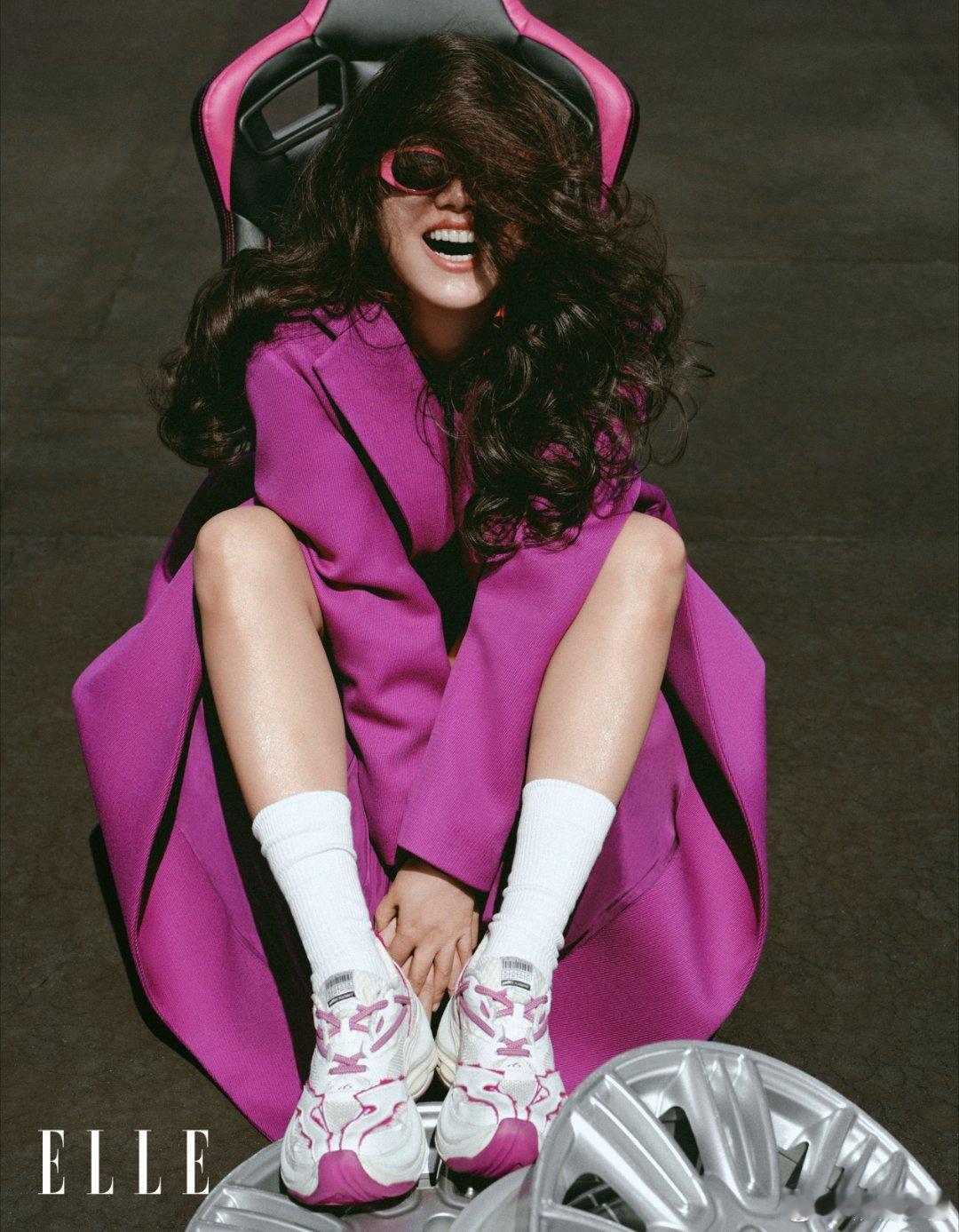 马思纯卷发如海藻翻涌，墨镜后藏着五月的晴朗，紫袍曳地似打翻的调色盘。皮衣裹挟风的