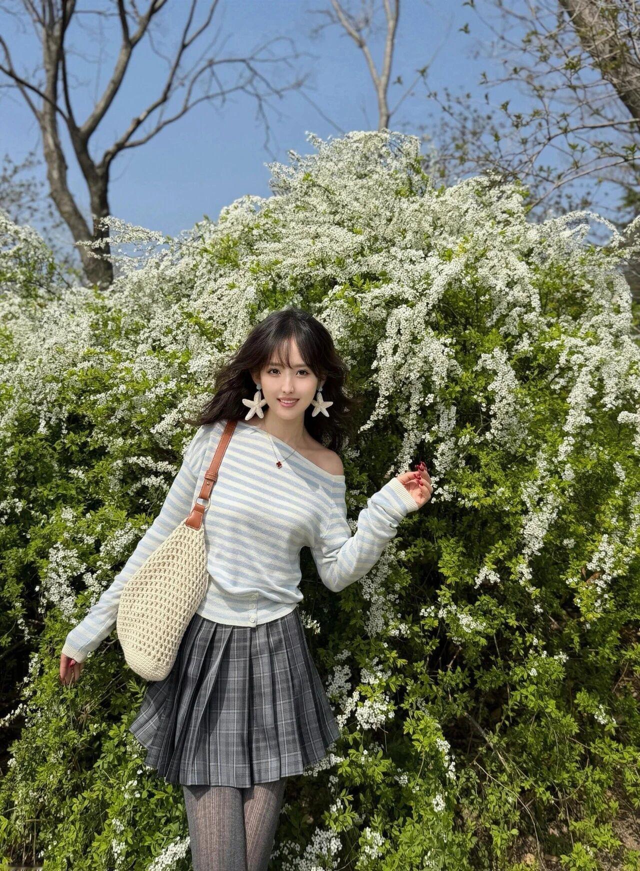 她有着温柔氛围感的慵懒卷发，眉眼清甜灵动，笑容干净治愈，气质温柔又元气，满满的春