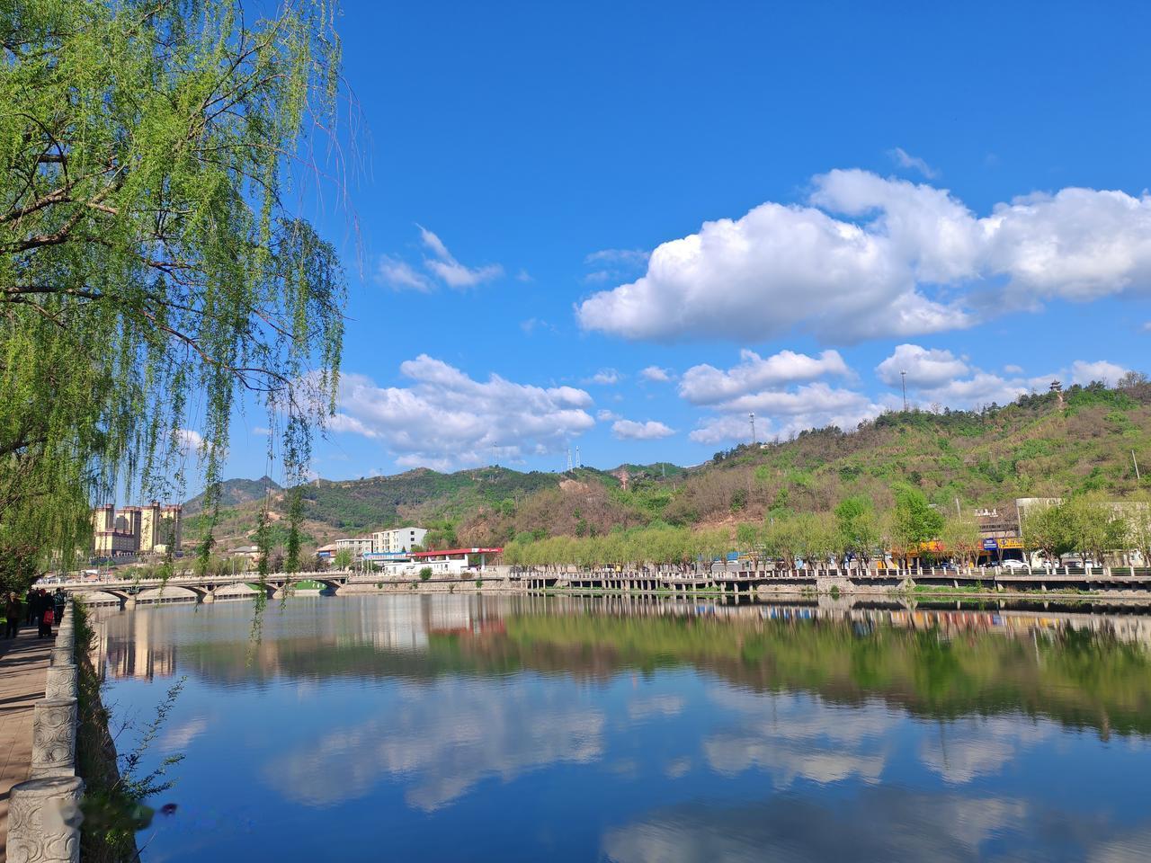 初夏的美，藏在随手一拍的画面里。蓝天澄澈，与翠绿秧苗相互映衬，农户们俯身田间插秧