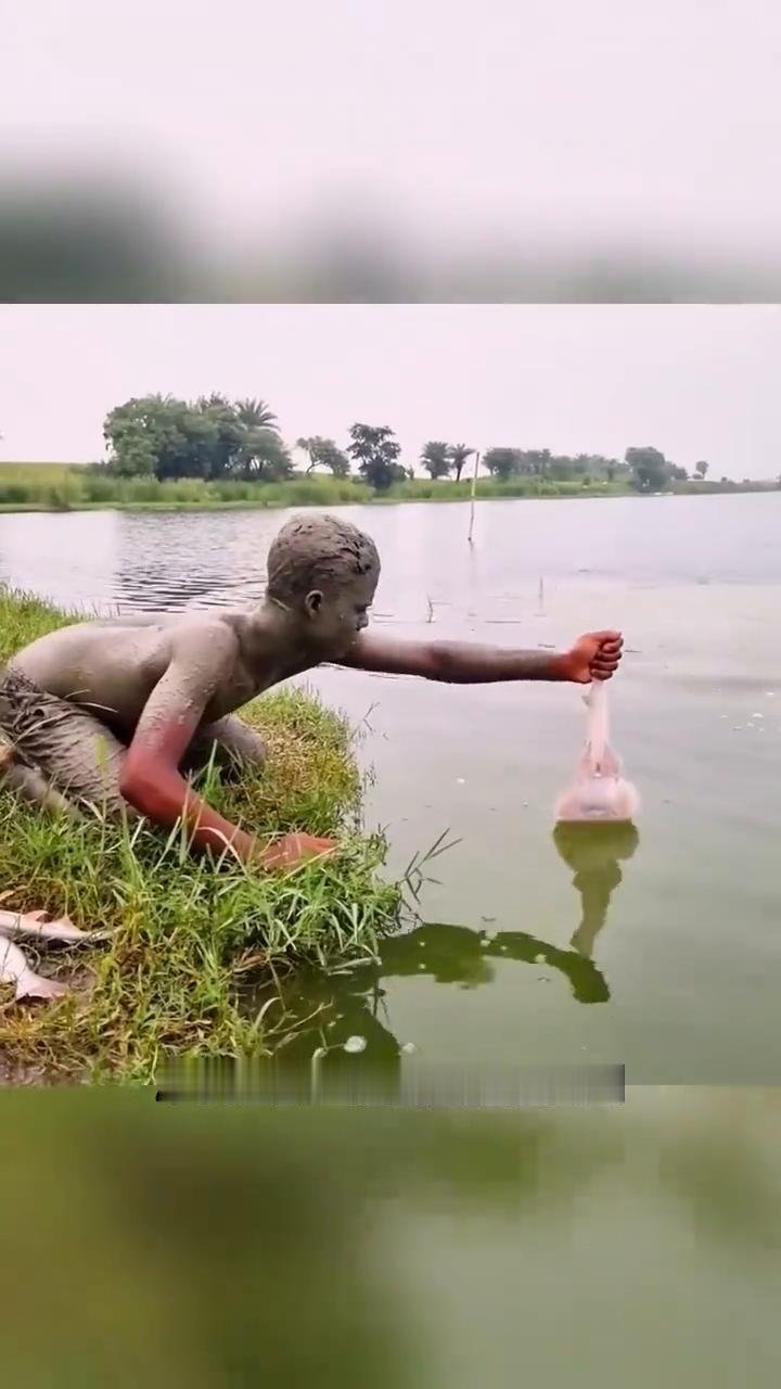 这个小伙真是个人才，左手拿着诱饵，右手就能徒手从水中抓到鱼，而且已经抓到3条了。
