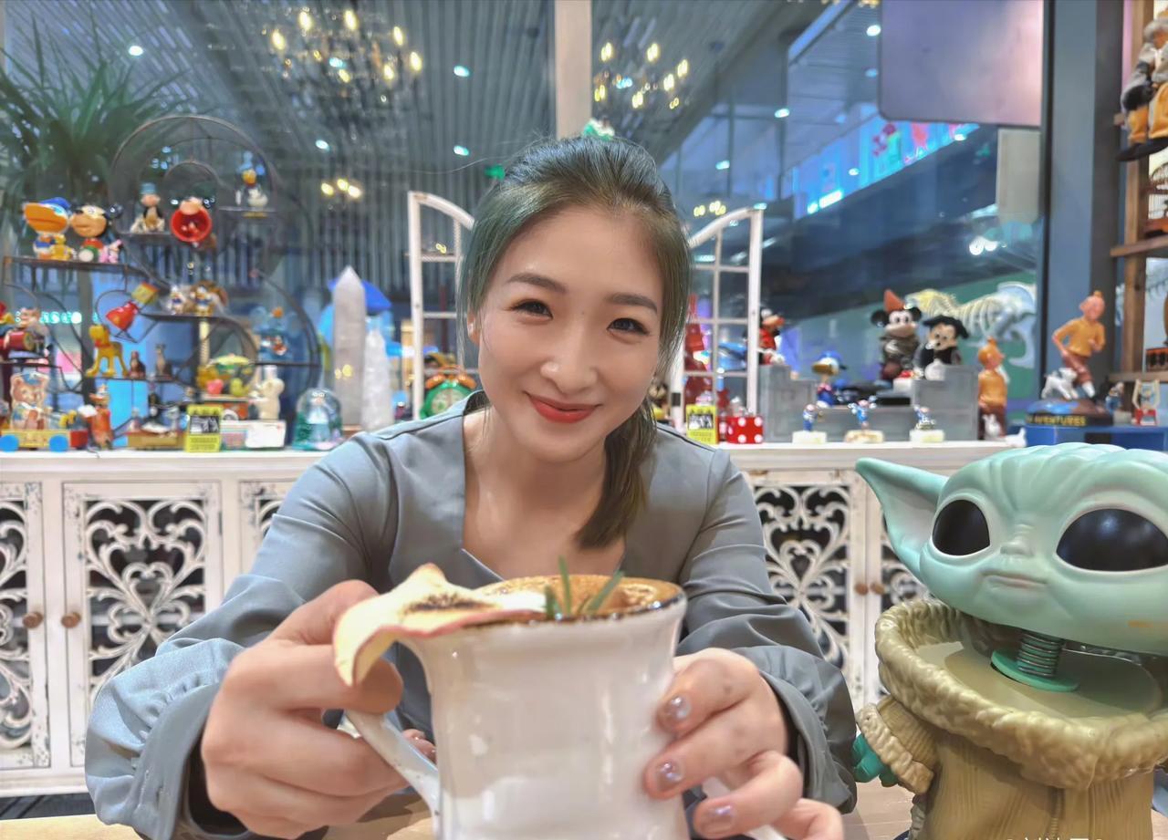 精致淡雅的妆容，清新自然的微笑！手拿一杯咖啡的她，满满的都是快乐的感觉。她就是来