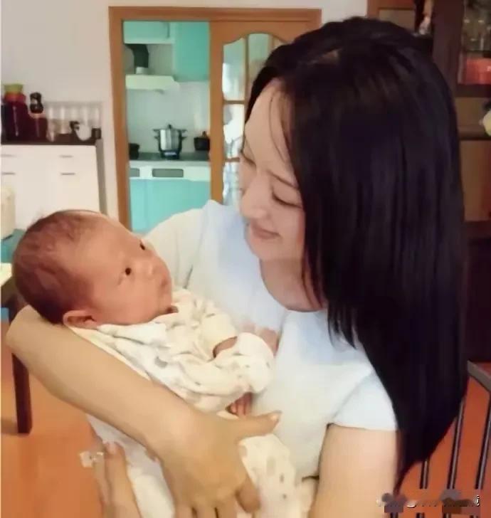 这是著名的女明星杨钰莹抱着孩子的照片，看起来爱意满满，看来她很喜欢小孩呀。
只可