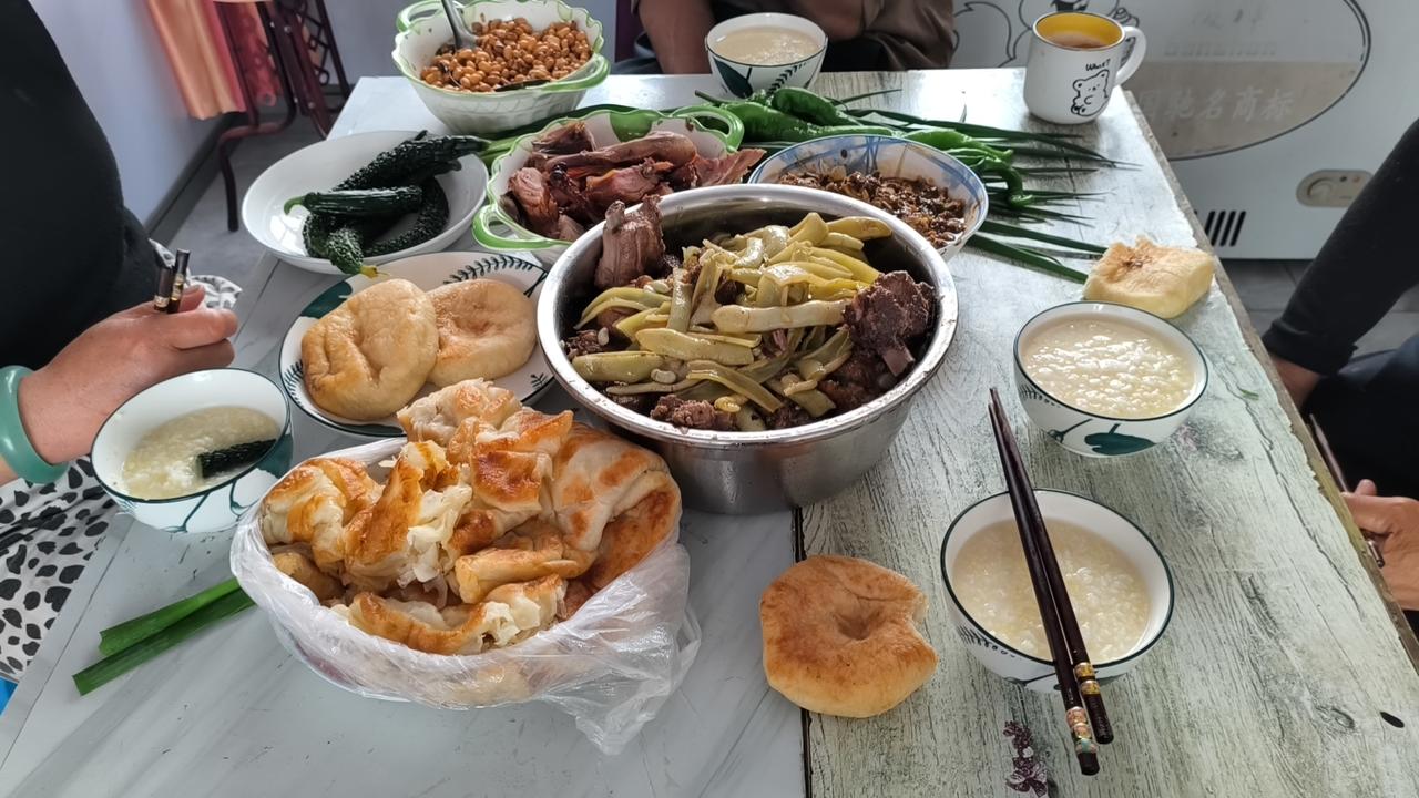 大铁锅下架着木头火，炖的排骨豆角，时不时地再来几口大葱蘸大酱，好吃到爆，吃到我撑