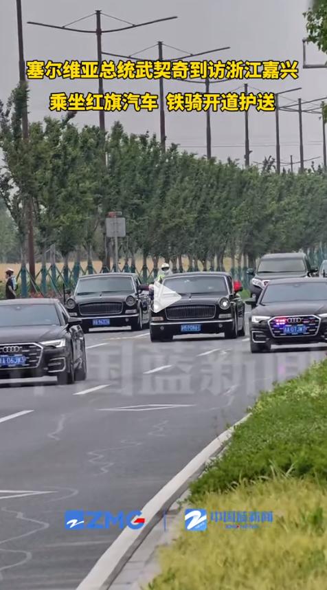 塞尔维亚总统武契奇的车队缓缓驶过，打头阵的是一辆国产红旗轿车，两侧铁骑全程开道护