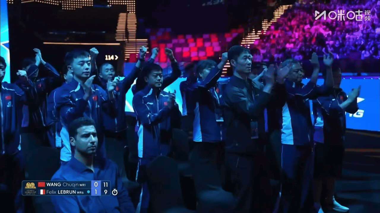 阿萨尔端坐在男乒旁边 