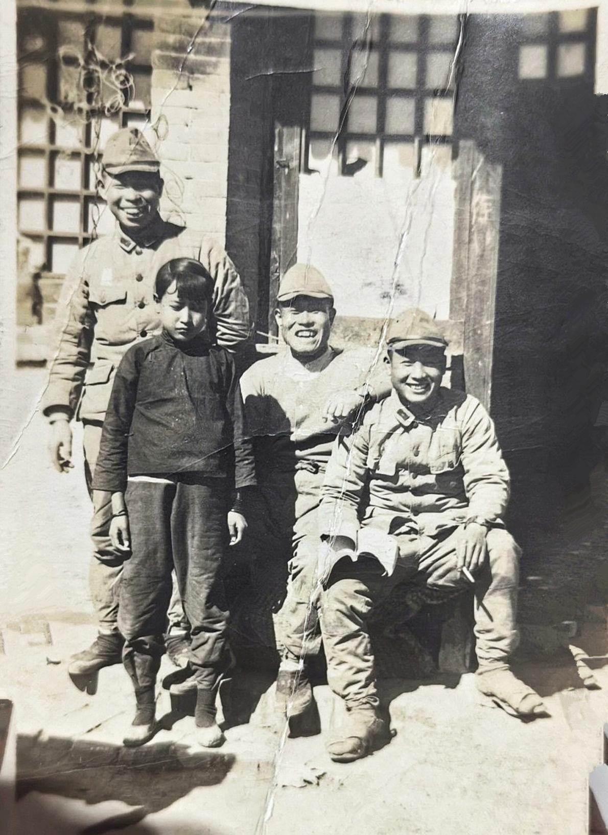 1937年，一名小女孩不幸落入三个日军之手。日军把她拉过来一起照片，所以留下了这