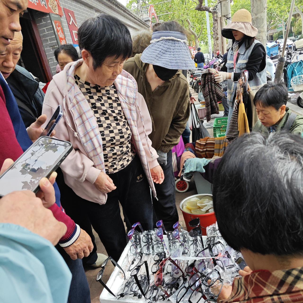 凑过去看了一下，原来是一卖眼镜的，有不少人在买呢。
因为我也不想买，所以也不知道