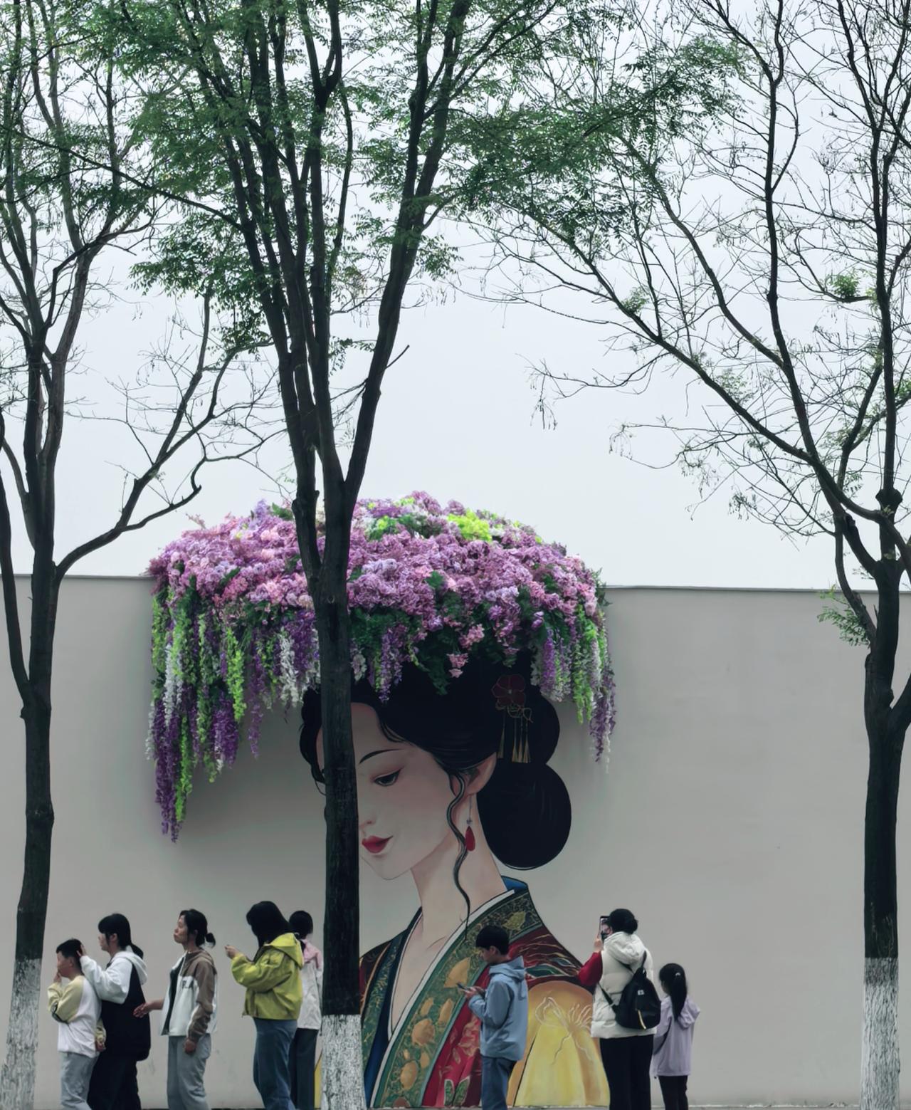 西安城市白墙，被一笔丹青晕染成诗，美人垂眸，花瀑作冠，路过的行人都成了配角，原来