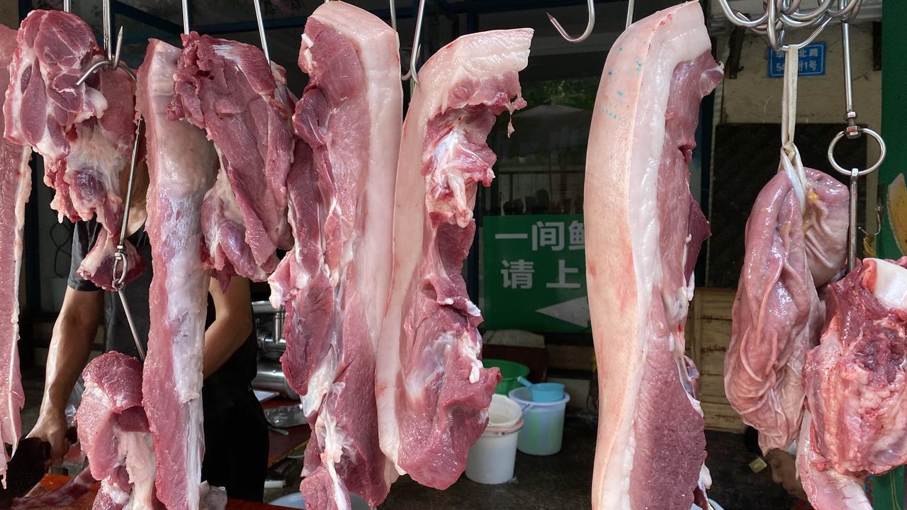 刚靠近肉摊我就停下脚步，铁架子一排排钩子悬在遮阳棚底下，各式各样的猪肉都挂在上边