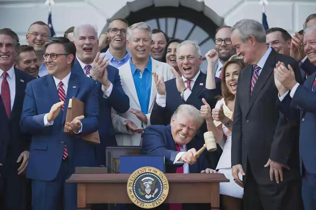 特朗普拿锤敲桌子，他身旁的人都在笑逐颜开，看起来是皆大欢喜的样子。