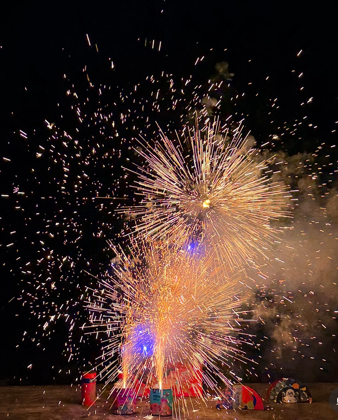 除夕夜的夜空，被一场盛大的烟火点亮。点燃引信的瞬间，彩色的烟花筒次第升空，金色的