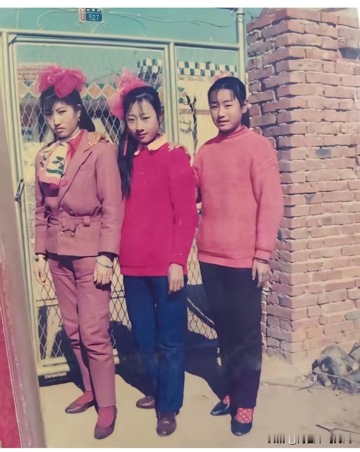 这三位女生穿、戴在那个年代是很时髦了，头扎丝巾花、身穿偏红衣服，二个扣子的西装，