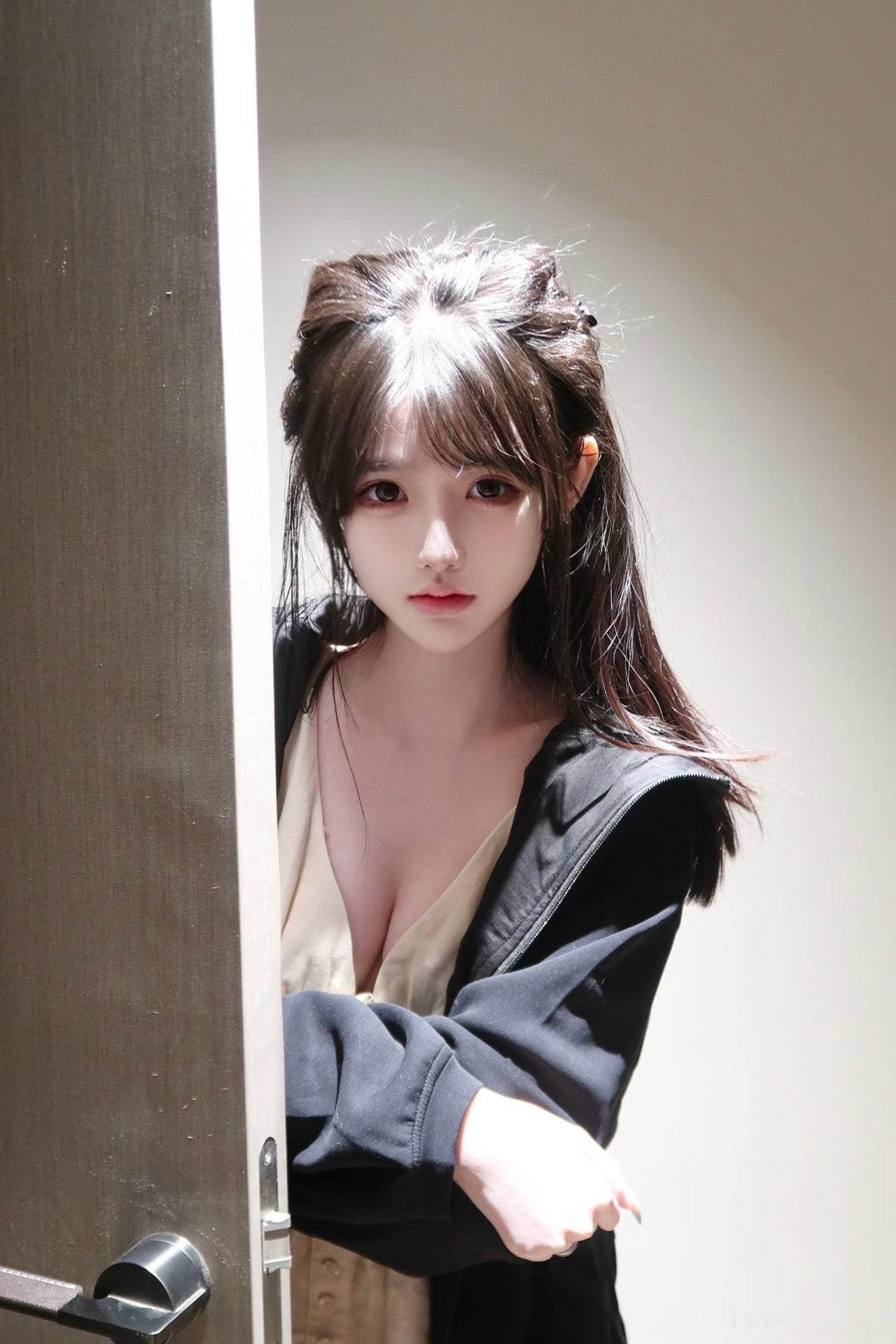 门后光影里的清冷瞬间，黑外套松垮搭在肩头，内搭浅色系吊带，松弛又带点小性感。半扎