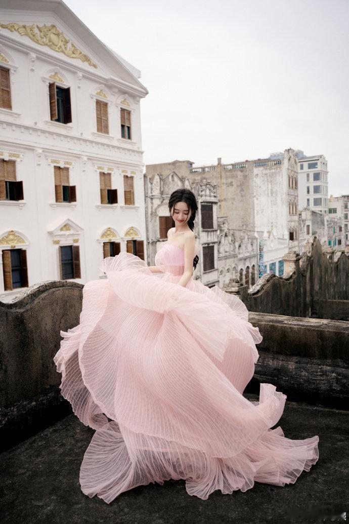 邓恩熙好明媚的生命力邓恩熙一袭粉纱裙立于天台，层叠褶皱如揉碎的云霞在风中舒展，抹