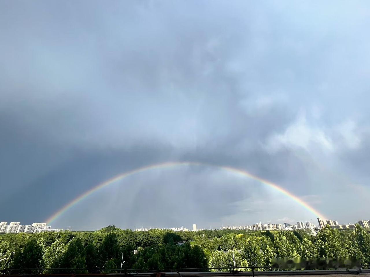 雨停了，城市上空挂起七彩桥

下午那场雨下得真叫大，豆大的雨点“噼里啪啦”砸在窗