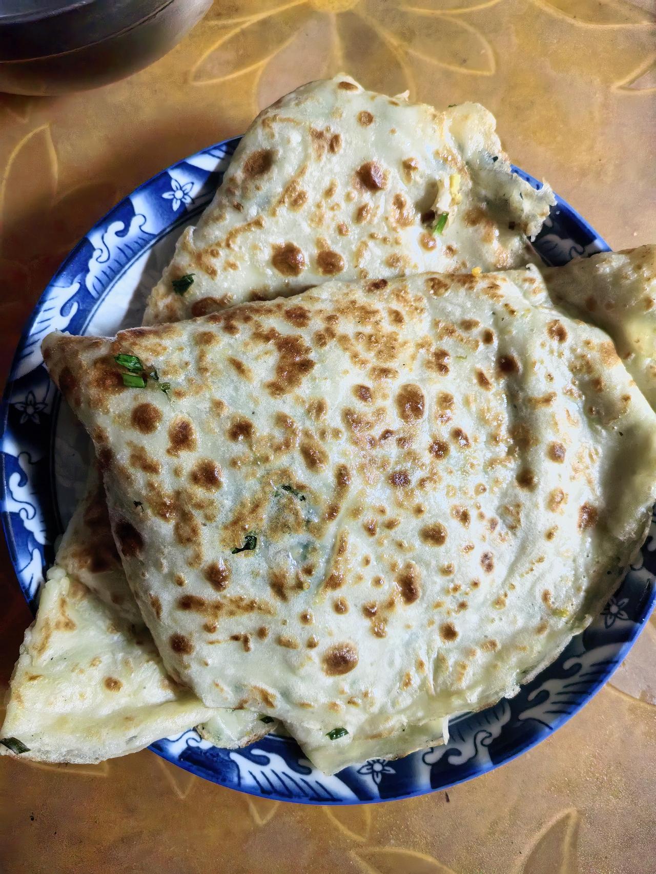 家常烙饼烟火飘香，外皮带着焦香的斑纹，层次松软，咬一口满是朴实的香气。不用繁复调
