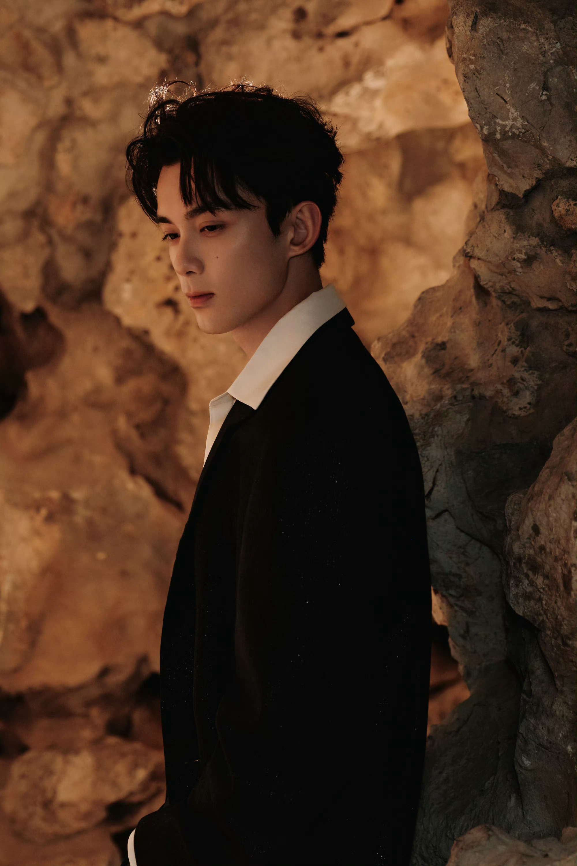 吴磊 品牌庆典活动造型，身着黑色长大衣，衬衫和网眼的层叠内搭，手捧鲜花而来的少年