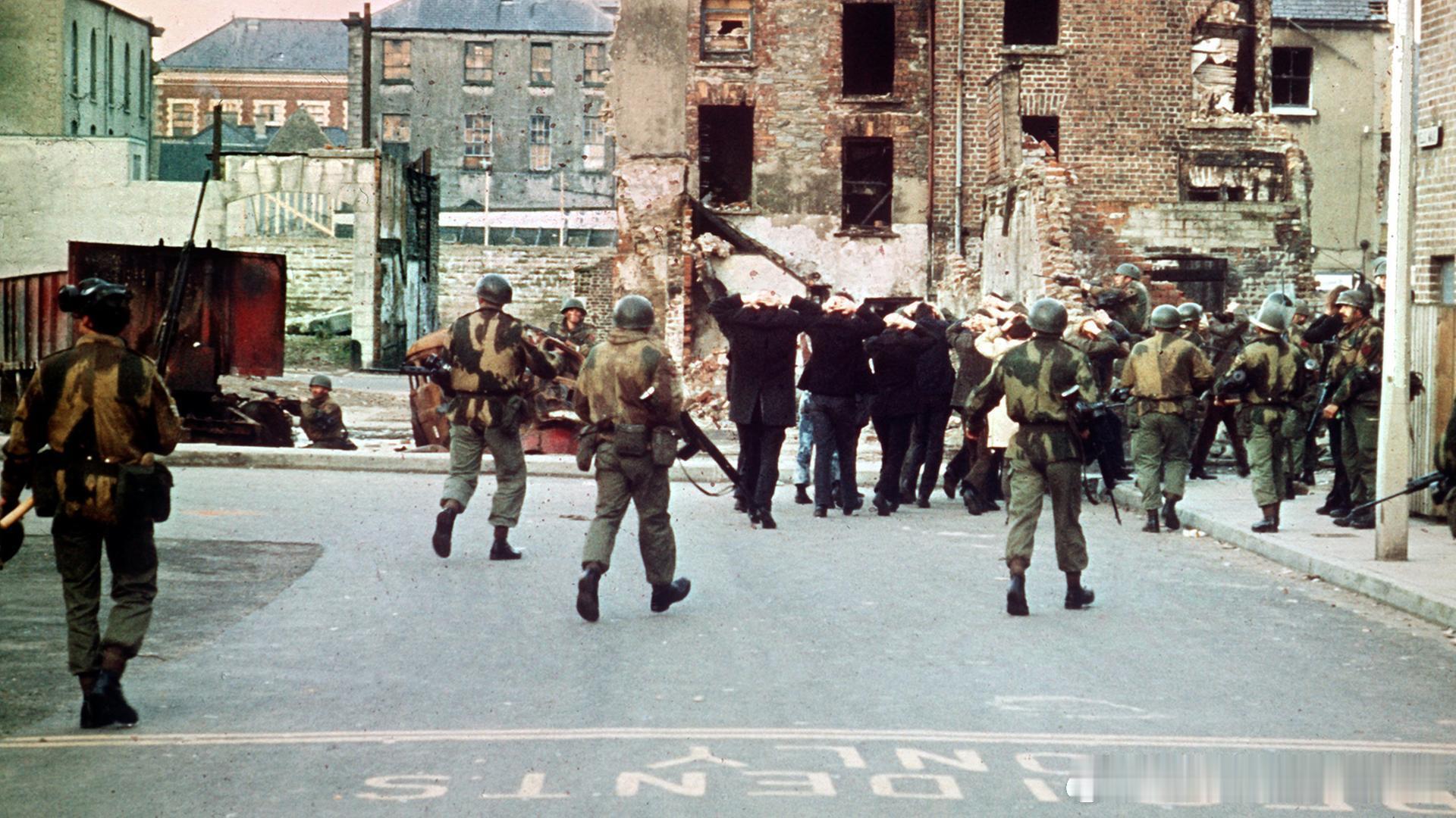 1972年1月30日北爱尔兰街头，一群手无寸铁的爱尔兰民众被全副武装的英军押解。