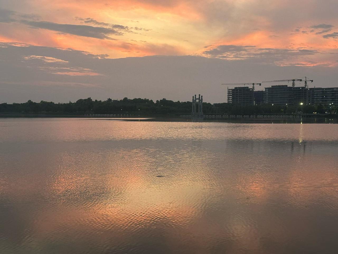 晒图笔记大赛水面接住了落日的余晖，把天空揉成温柔的橘色。远处的轮廓浸在暮色里，连