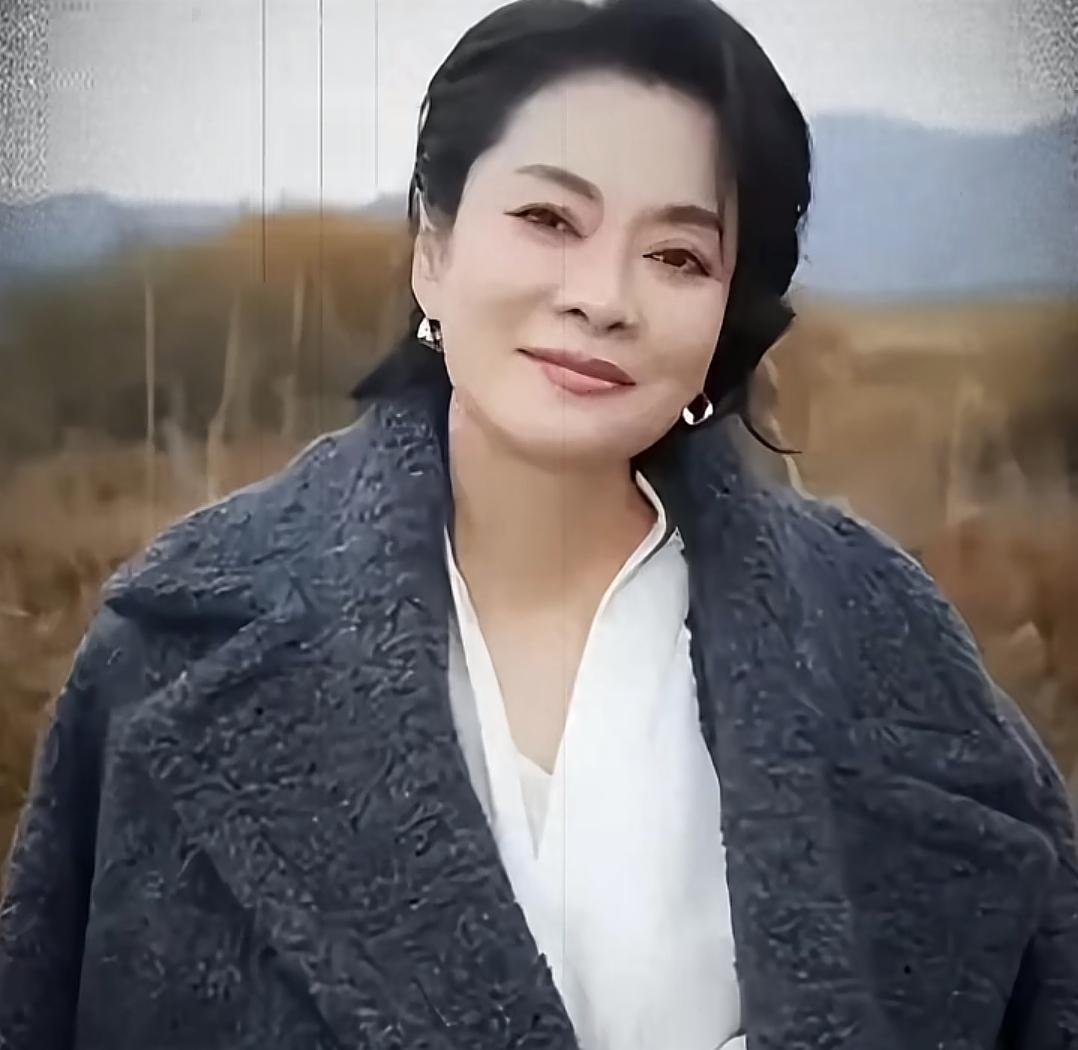 一位女士在田野中微笑。她是谷建芬最好的学生吗？最有实力的大姐大。在女歌手中至今没