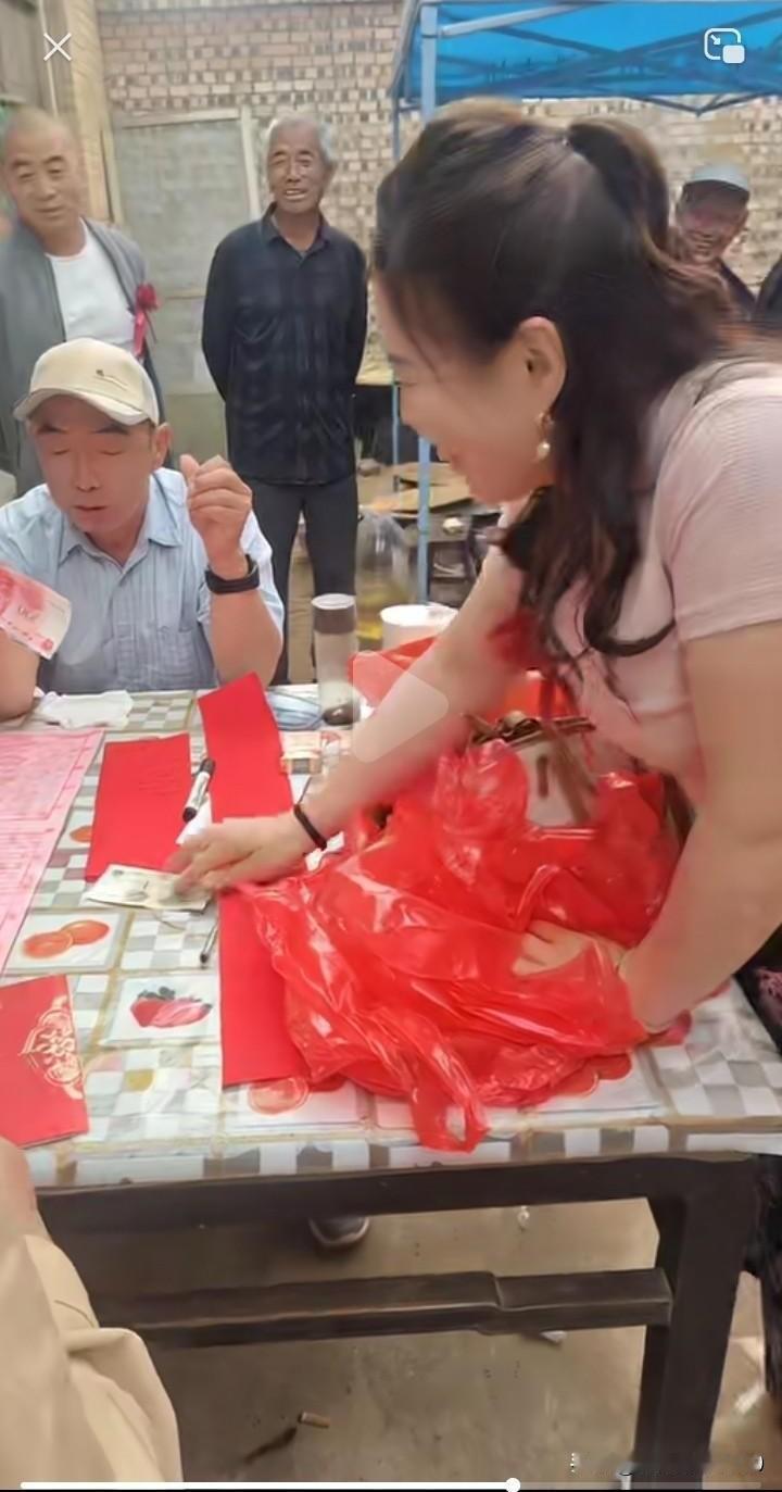 你瞧，结婚随礼这风俗挺有趣。一位漂亮女客人，用十个红色塑料袋各包1块钱，又用6个