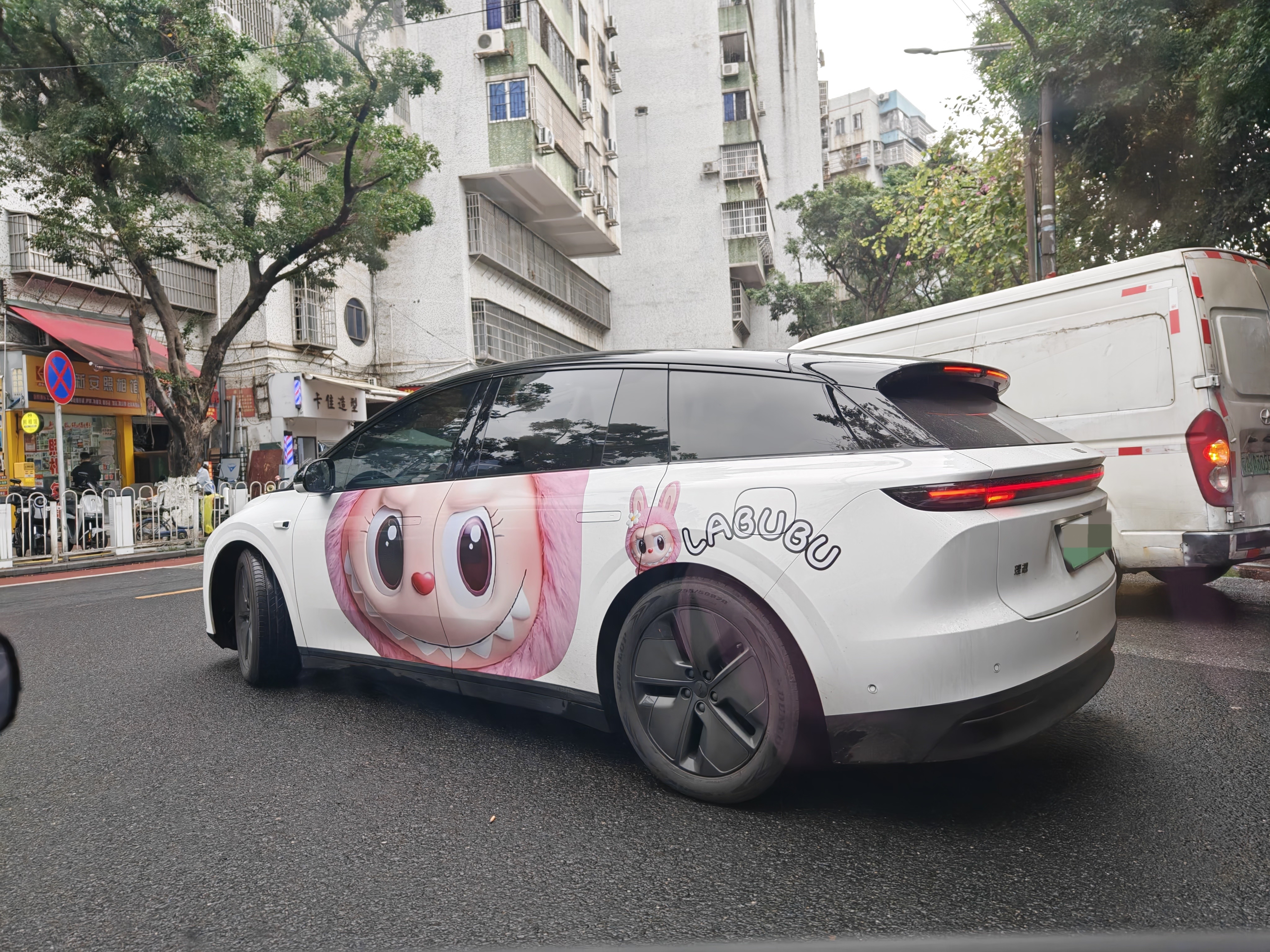 路上遇到一辆贴了Labubu车衣的i6车身两侧还是不一样的图案，看起来像是一对情