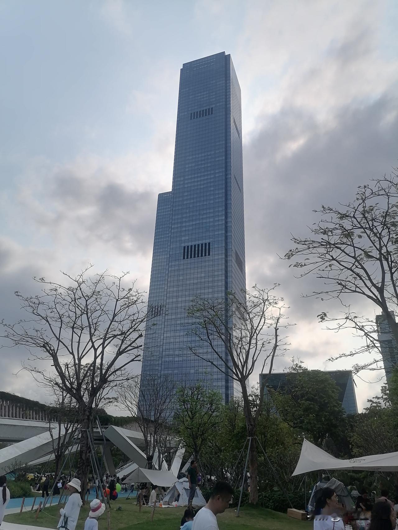 市民在公园休闲玩耍，公园边大楼高耸入云鹤立鸡群！