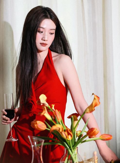 卢昱晓红裙 卢昱晓工作室发布姐姐身着正红色挂脖连衣裙的造型，裙身点缀立体玫瑰装饰