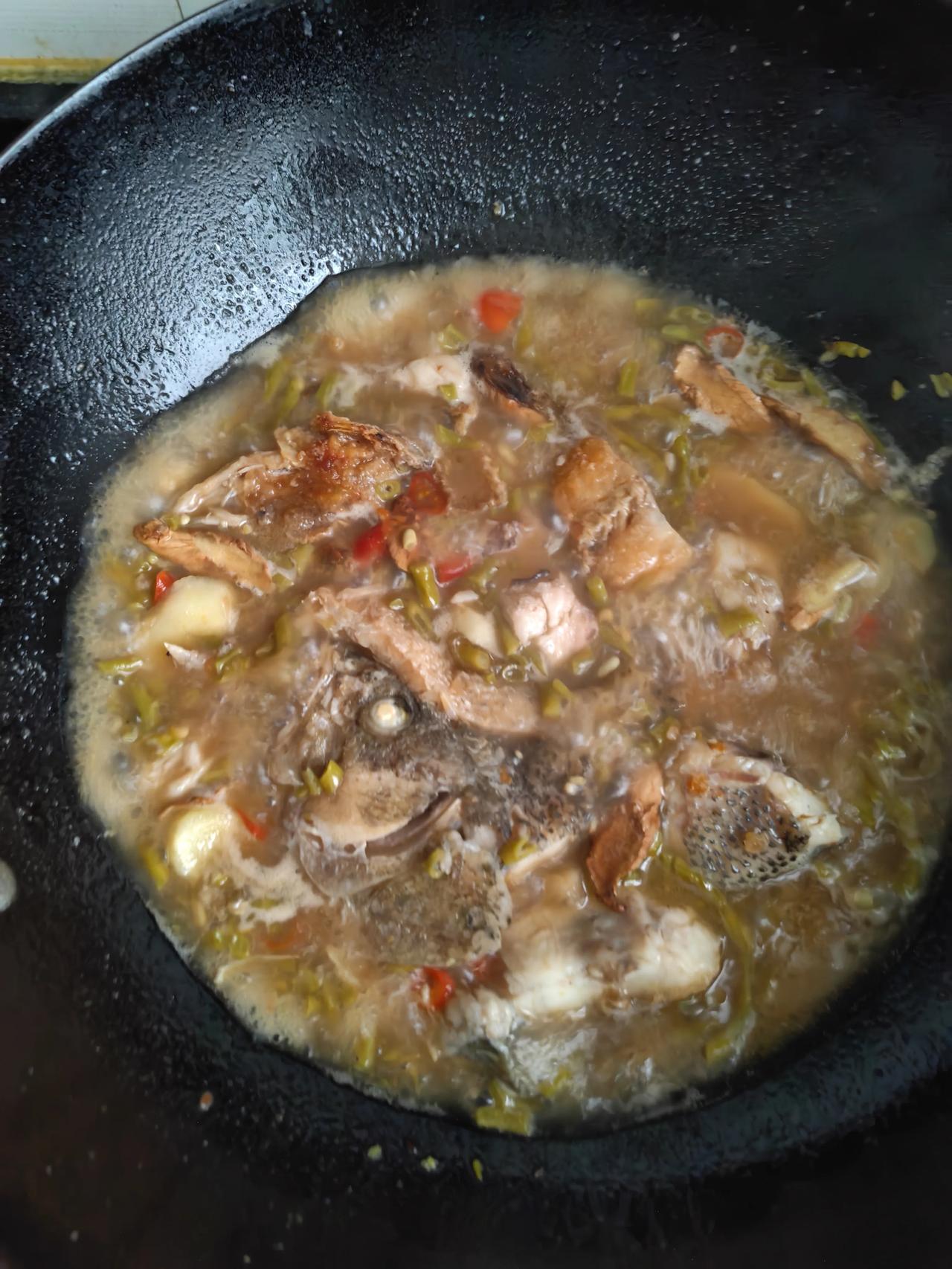 酸豆角焖鱼
 
今天家里做酸豆角焖鱼。首先把处理干净的鱼切块，放进铁锅煎，煎到鱼