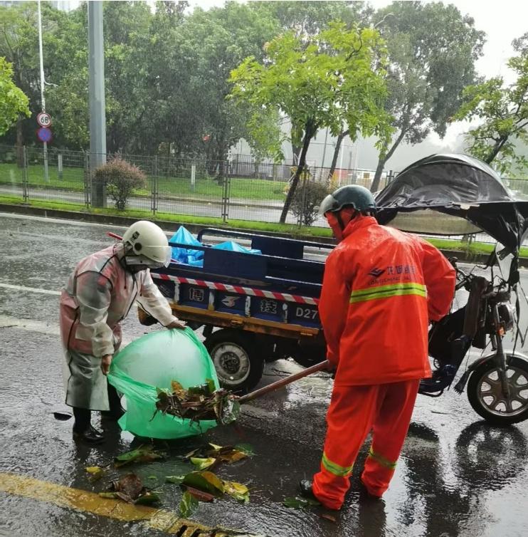 风雨中，环卫工人清理雨水箅子，反复清掏箅子中的杂物，扫清入水口周围的落叶、垃圾袋