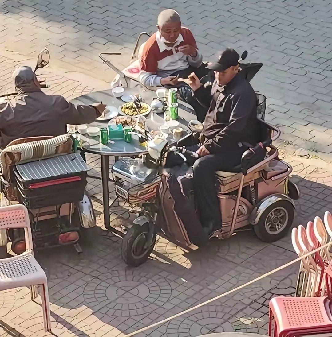 街头三位残疾老伙计坐轮椅相聚畅饮言欢 ​​​