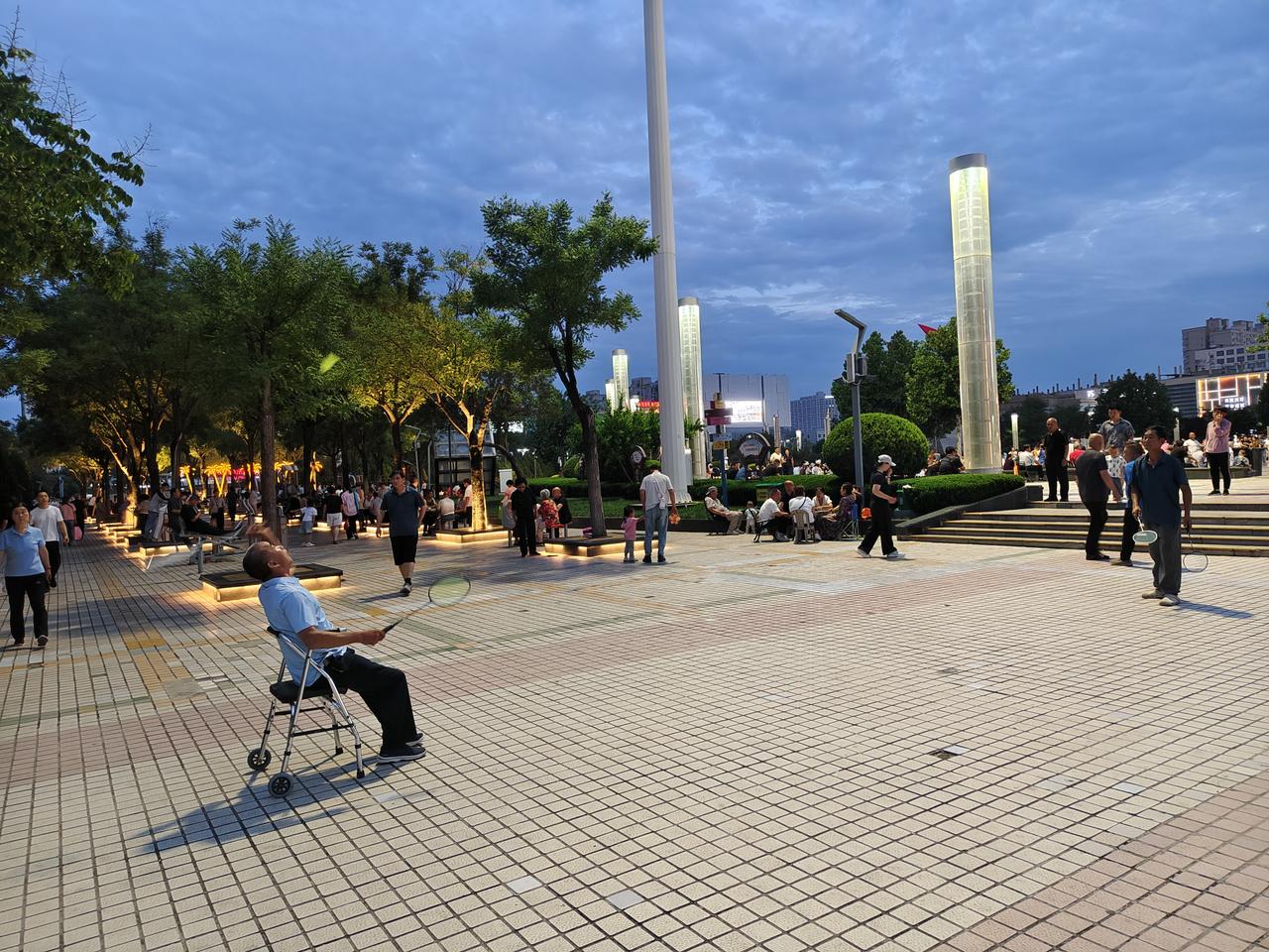 您瞧，在运城盐湖南风广场，一位大叔腿脚不便，但他坐在椅子🪑上，依然是左右开弓在