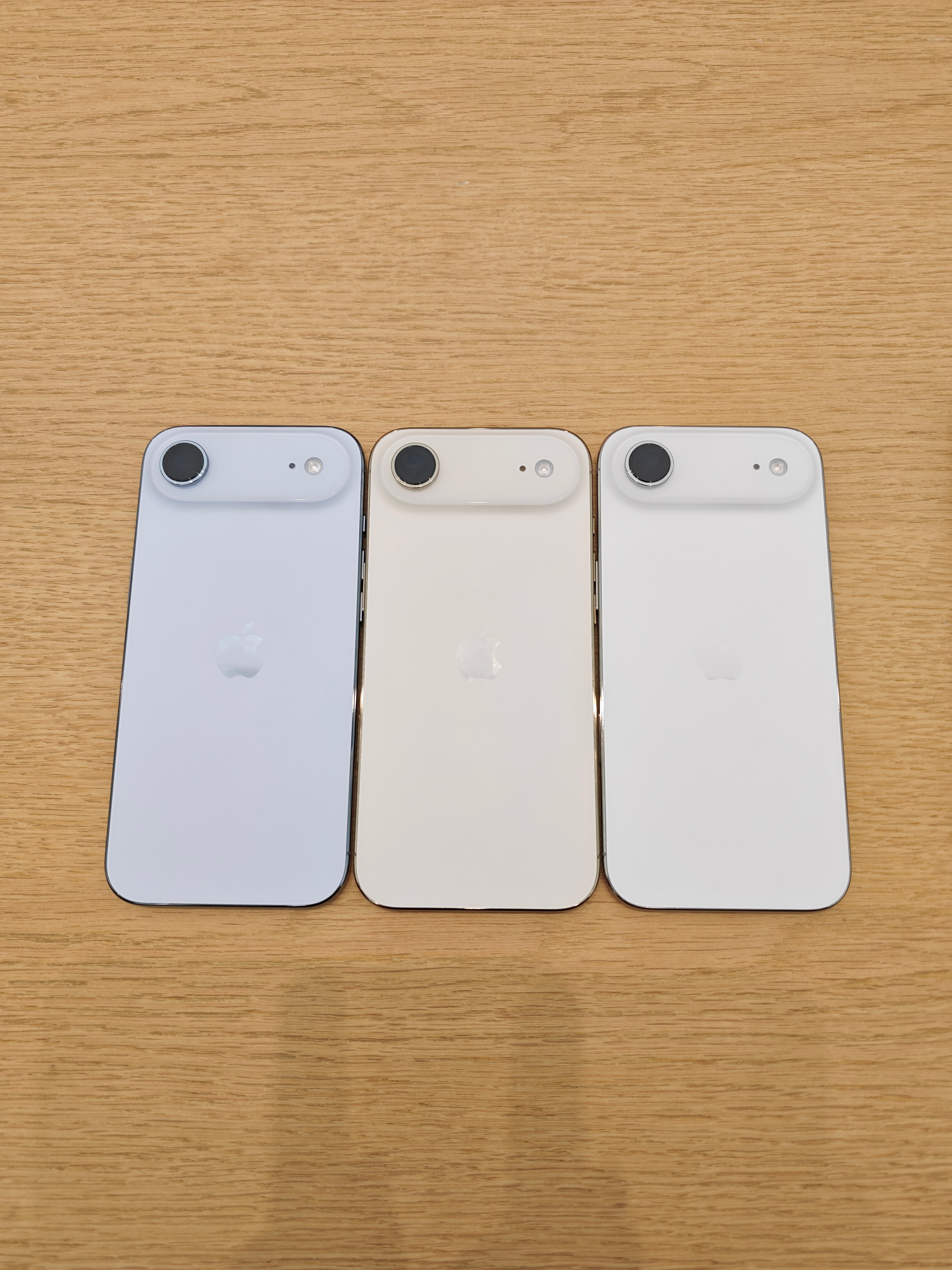3种颜色的iPhone Air，在Apple旗舰店的灯光下，如果不放在一起看很难