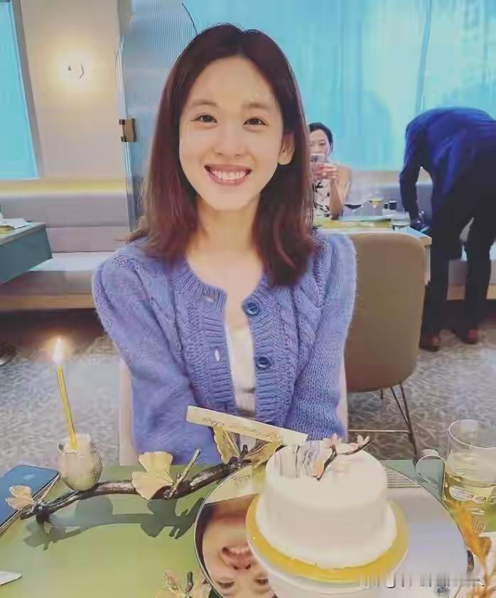 章泽天笑盈盈，她的笑脸在桌面镜子上，这桌子特别，还有桌面镜子可以放蛋糕。